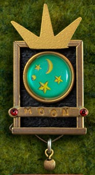 Shadowbox Pins are antiqued brass boxes featuring handmade image buttons, stamped word bars and vintage stones.